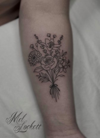 Fine line flower bouquet tattoo on the inner forearm